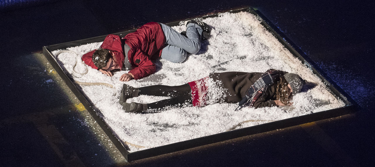 Photo d'un spectacle, deux personnes couchées par terre. 
