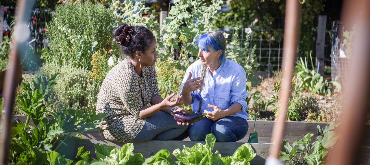 Deux femmes discutant dans un jardin potager 