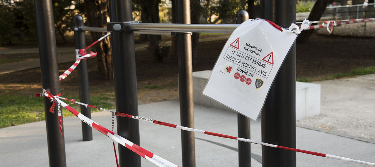 poteaux avec fil plastique rouge et blanc et affiche indiquant que le lieu est fermé jusqu'à nouvel avis par mesure de précaution