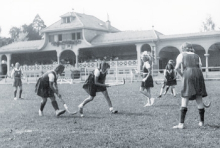 photo en noir et blanc sur laquelle on voit des femmes habillées en robe jouer à la crosse
