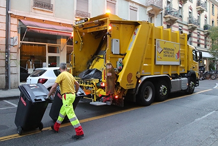 camion de la voirie avec personnes qui poussent une poubelle