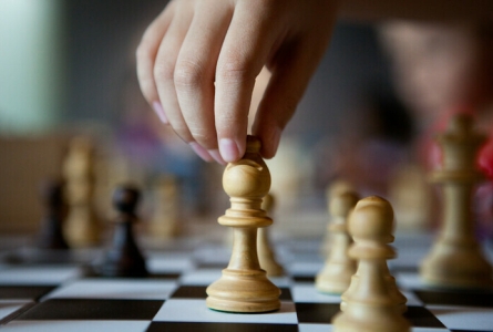 Image d'une main qui attrape une pièce d'échecs