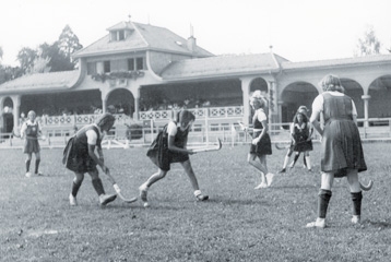 photo en noir et blanc sur laquelle on voit des femmes habillées en robe jouer à la crosse