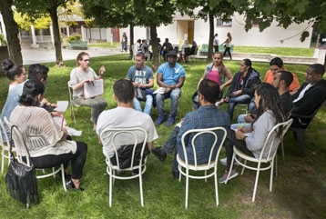 Des gens dans un jardin assis en cercle pour une réunion
