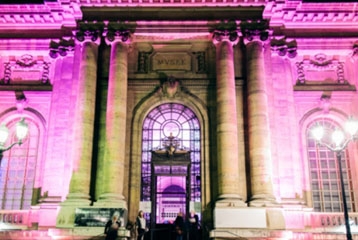 image d'une façade avec colonnes, illuminée d'une couleur rose