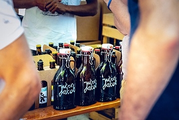 bouteilles brunes avec l'inscription "père Jacob" posées devant des cartons de bière