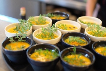 petits bols avec soupe orange et décoration végétale