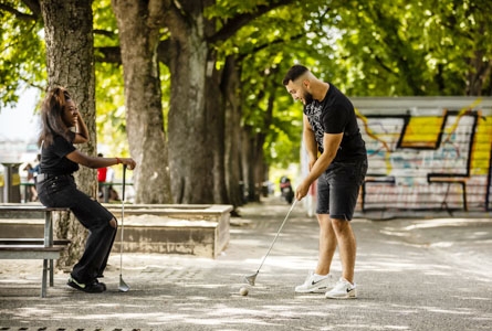 Deux jeunes gens pratiquent le golf urbain à Genève sur la Treille