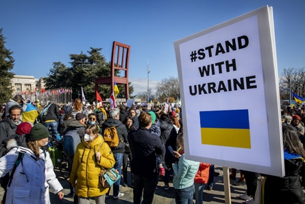 manifestation avec personnes et pancartes aux couleurs de l'Ukraine