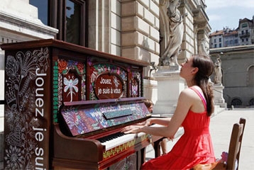 femme en rouge qui joue sur un piano décoré