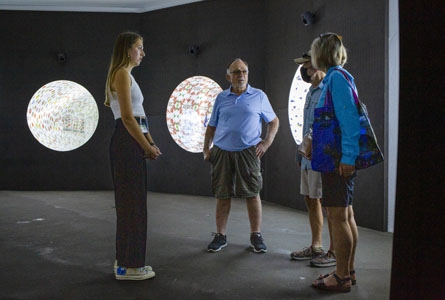 Une jeune femme gardienne discute avec des touristes dans un musée