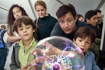 enfants et adultes devant une sphère avec de l'électricité