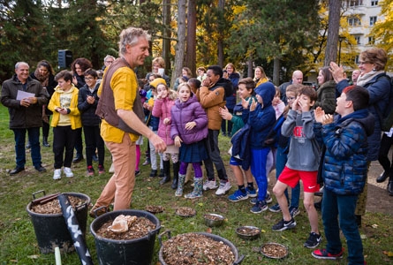 Un groupe d'enfants plante des arbres avec une troupe de théâtre