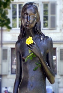 Buste de jeune fille frêle en fonte, tenant une rose jaune dans sa main gauche repliée sur le buste