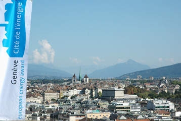 Une bannière "Genève Cité de l'énergie" est au premier plan d'une vue panoramique de la ville.