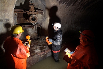 Des ouvrier inspectent une valve dans un égout