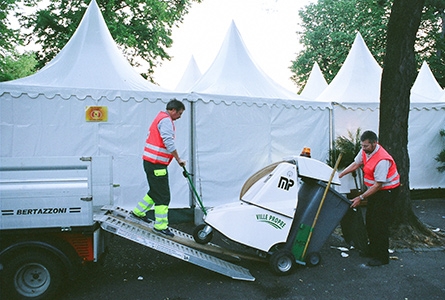 Des employée de la voirie transportent une machine destinée à nettoyer les rues
