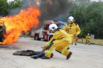 deux sapeurs pompiers sortent un objet d'une voiture en feu