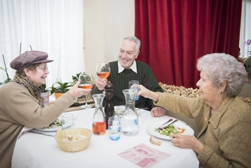 trois personnes âgées se retrouvent autour d'une table pour l'événement du même nom