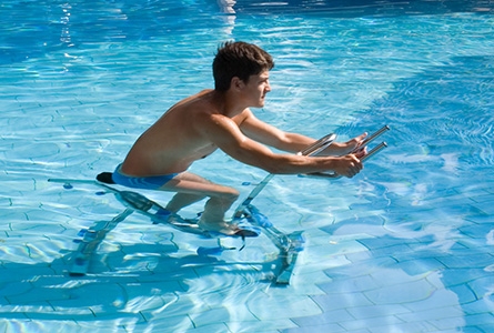 Un jeune homme fait de l'aquabike dans une piscine