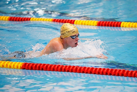 Un nageur en pleine course dans une piscine olympique