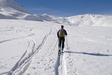 Un homme pratique le ski de randonnée en montagne