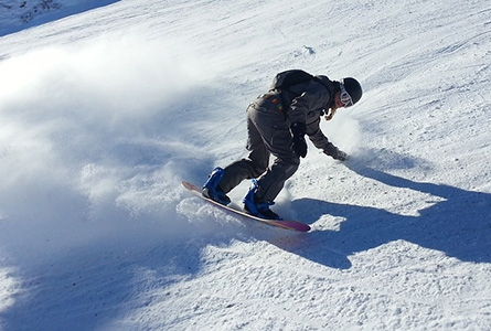 Un homme fait du snowboard en montagne