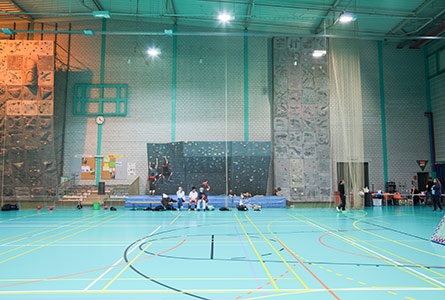 l'intérieur d'un centre sportif, un terrain multisport et un mur de grimpe