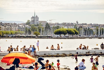 rade de Genève avec de nombreuses personnes en maillot de bain sur la plage ou dans l'eau