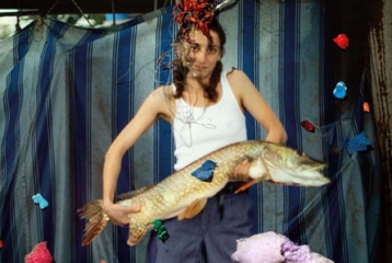 jeune fille qui tient un gros poisson dans les bras