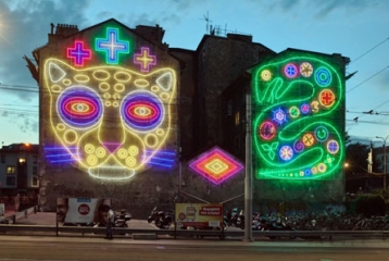 oeuvre lumineuse représentant un jaguar et un serpent, sur une façade